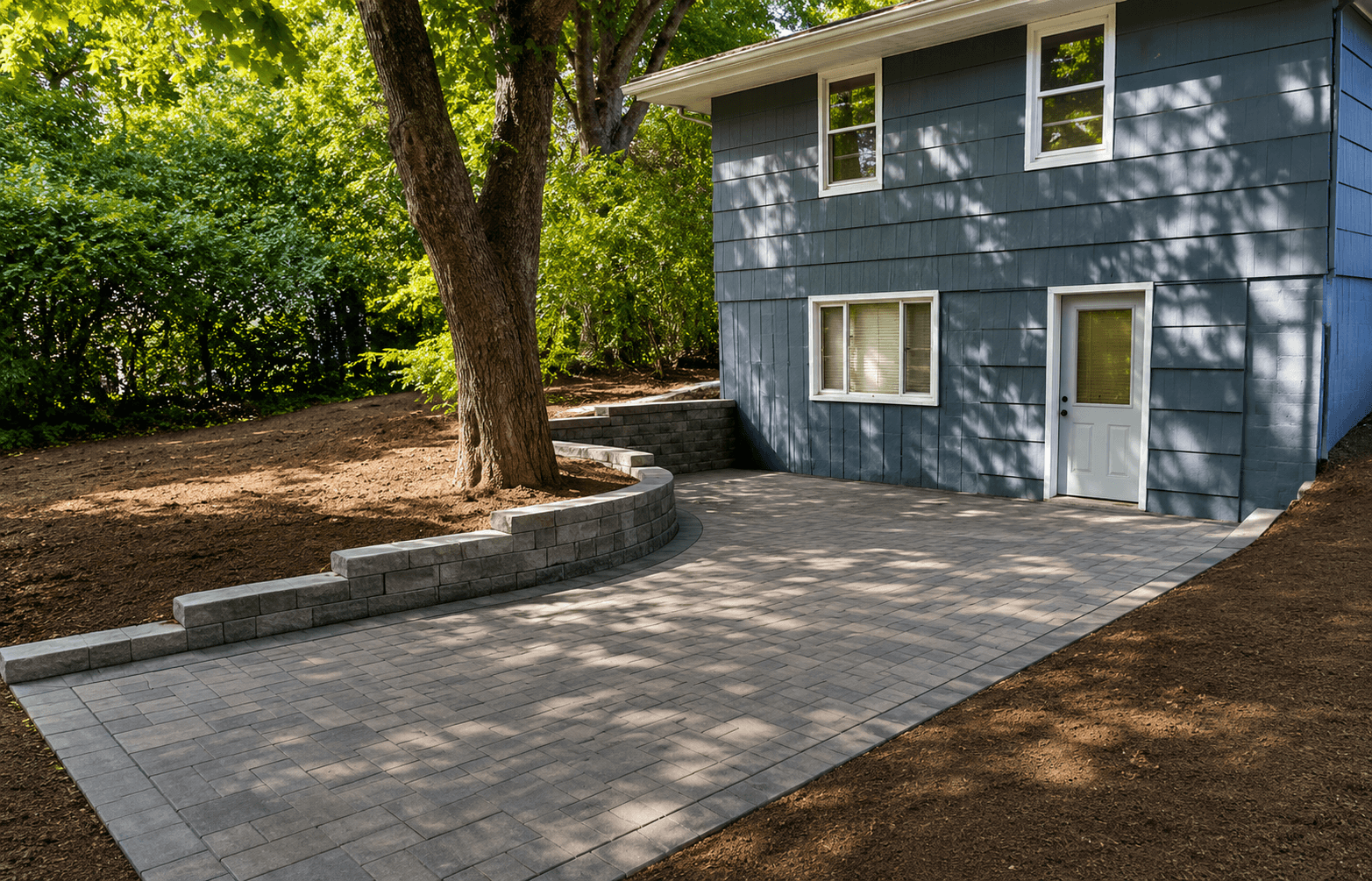 Paver patio with curved retaining wall and walkout basement access